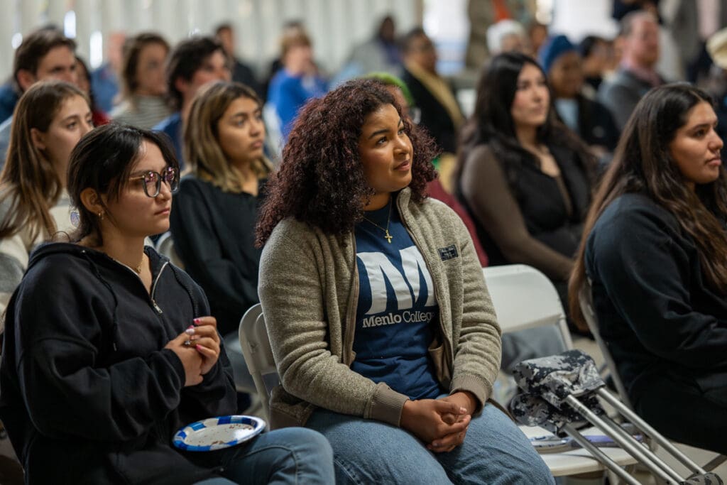 Menlo College students seated in the Student Union listen to special guest speakers.