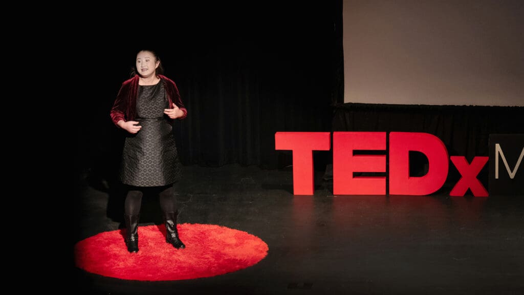 Professor Lan Jiang delivers a TEDxMenlo College talk onstage.