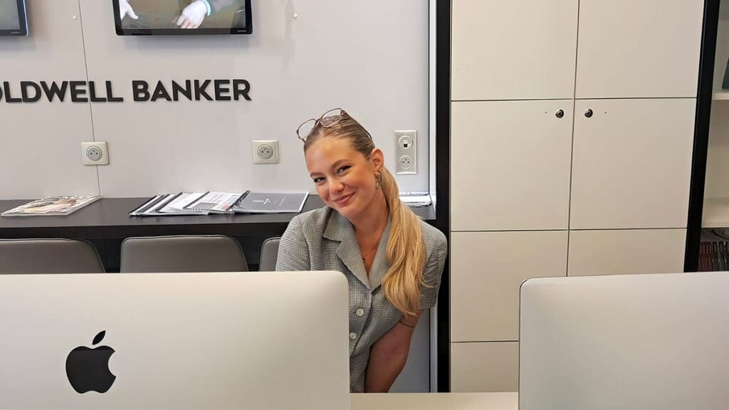 Menlo College International Business student Juliette Chabrier sits at a desk at the Coldwell Banker Paris office during her summer internship in luxury real estate.
