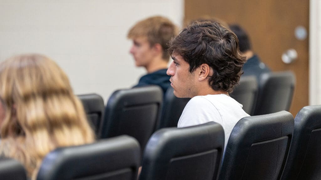 Menlo College students sit attentively in a classroom, listening to guest speakers discuss entrepreneurship during Dr. Fabian Eggers’ class.