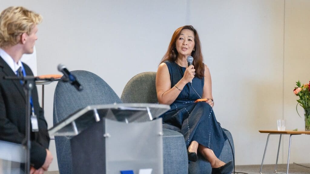 Christina Bui, Vice President of Managed Business Solutions at Robert Half & Protiviti, speaks into a microphone while seated onstage during Menlo College’s Finance Hybrid Conference 2026.