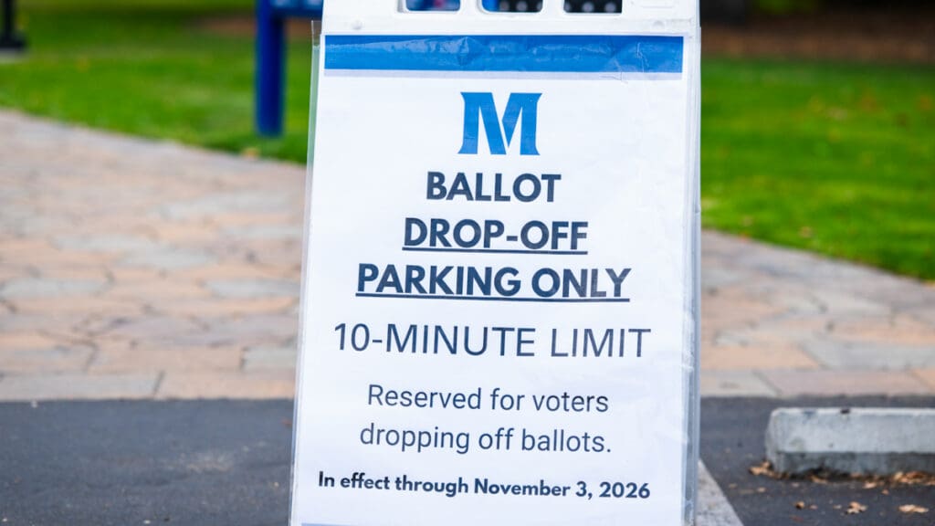 A Menlo College ballot drop-off parking sign near the campus entrance designates 10-minute parking for voters returning ballots, with restrictions in effect through November 3, 2026.