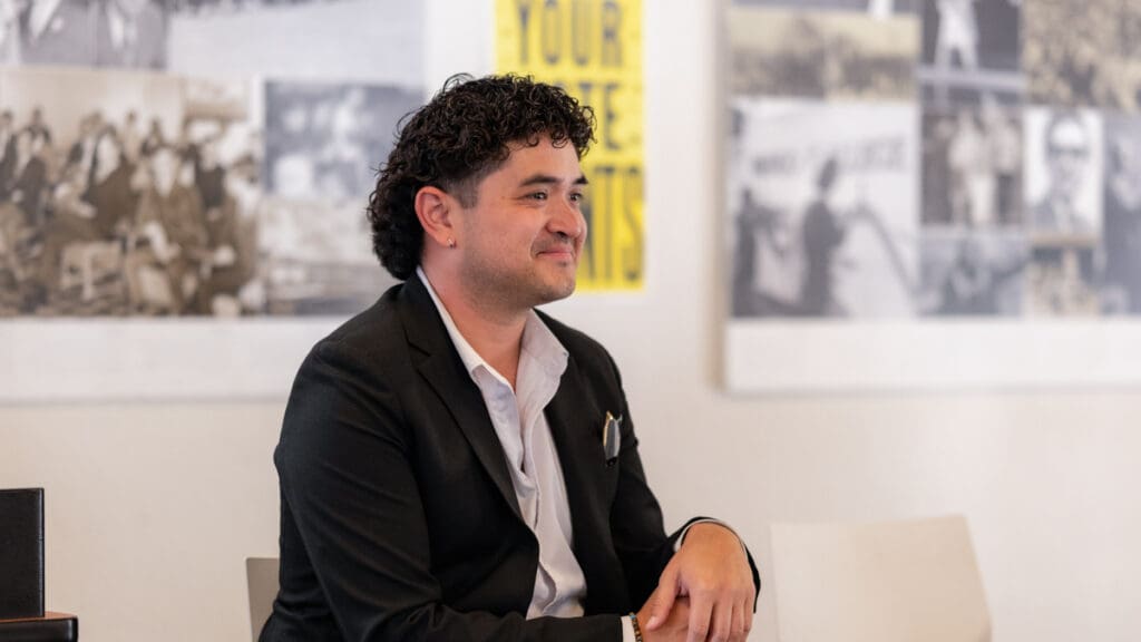 Political consultant Jason Galisatus sits smiling during the Civic Engagement Forum at Menlo College on October 7, 2026, wearing a black blazer and white shirt.